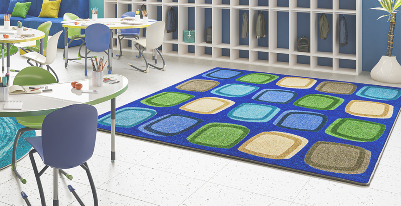 Classroom setting with a large seating carpet decorated with rocks in an earthy colour tone..